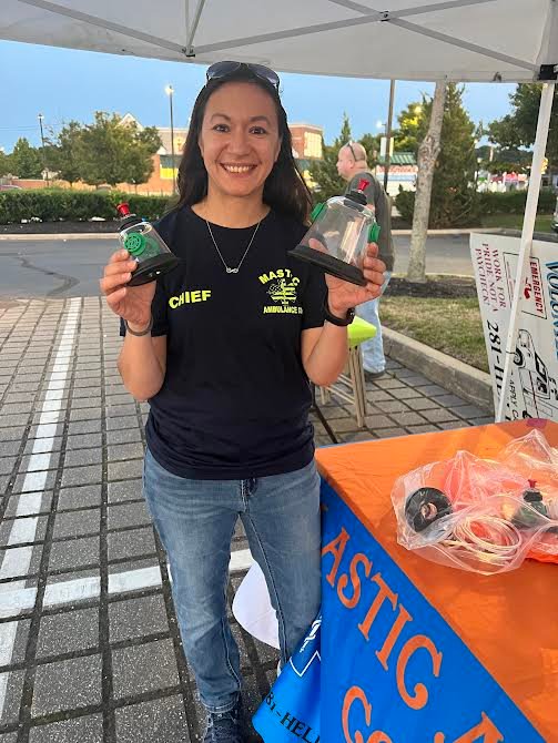 Jennifer Lian, assistant chief at Mastic Ambulance, holding up pet masks for dogs and cats to receive oxygen after being rescued from a fire by EMS workers.